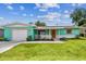 Charming single-story home with a well-manicured lawn, bright exterior, and a driveway leading to an attached garage at 11250 108Th Ln, Largo, FL 33778