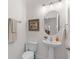 Powder room features a pedestal sink, oval mirror, framed art, and soft lighting at 11419 Emerald Shore Dr, Riverview, FL 33579
