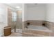 Beautiful bathroom features soaking tub with decorative tile, tiled shower with glass door, and natural light at 11419 Emerald Shore Dr, Riverview, FL 33579