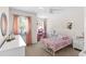 Cozy bedroom with plush carpet, white furniture, pink curtains, and a unicorn themed bed set at 11419 Emerald Shore Dr, Riverview, FL 33579