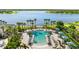 Stunning community pool with lounge chairs, pergolas, and palm trees overlooking a serene lake at 11419 Emerald Shore Dr, Riverview, FL 33579