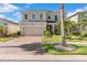 Lovely two-story home displaying a brick driveway, lush landscaping, and a welcoming front facade at 11419 Emerald Shore Dr, Riverview, FL 33579
