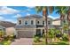 Charming two-story home featuring a brick driveway and lush tropical landscaping at 11419 Emerald Shore Dr, Riverview, FL 33579