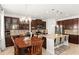 Open concept kitchen with dark cabinetry, granite counters, tile backsplash, stainless appliances, and island with barstool seating at 11419 Emerald Shore Dr, Riverview, FL 33579