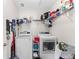 Functional laundry room with modern washer and dryer, storage shelving and vacuum at 11419 Emerald Shore Dr, Riverview, FL 33579
