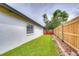 Backyard with a wooden fence, lush lawn, decorative rocks, and outdoor seating at 11520 Bear Paw Ln, Port Richey, FL 34668