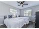 Cozy bedroom featuring two twin beds with matching starfish pillows, a ceiling fan, and natural light from two windows at 11520 Bear Paw Ln, Port Richey, FL 34668
