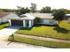 Well-maintained single-story home with a lush green lawn, a two-car garage, and a neatly landscaped front yard at 11520 Bear Paw Ln, Port Richey, FL 34668