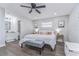 Well-lit main bedroom with a full bathroom, a comfortable bed, and wood flooring at 11520 Bear Paw Ln, Port Richey, FL 34668