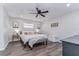 Serene main bedroom with a comfortable bed, accent furniture, and wood flooring at 11520 Bear Paw Ln, Port Richey, FL 34668