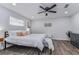 Bright main bedroom with a comfortable bed, modern decor, and stylish wood floors at 11520 Bear Paw Ln, Port Richey, FL 34668