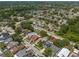 This is an aerial view of a neighborhood featuring lush trees, homes, and in-ground pools at 1213 Barmere Ln, Brandon, FL 33511