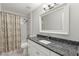 Bathroom featuring blue granite countertop, stylish fixtures, and a shower with tile surround and decorative shower curtain at 1213 Barmere Ln, Brandon, FL 33511