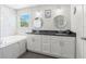 Modern bathroom with double vanity, granite countertop, marble tile and soaking tub at 1213 Barmere Ln, Brandon, FL 33511