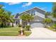 Charming gray two-story home featuring a well-manicured lawn, mature palms, and a two-car garage at 1213 Barmere Ln, Brandon, FL 33511