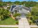Two-story home with mature trees, green grass, lush landscaping, solar panels, and a two-car garage at 1213 Barmere Ln, Brandon, FL 33511