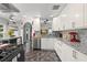 Modern kitchen features granite countertops, stainless steel appliances, and tiled floors at 1213 Barmere Ln, Brandon, FL 33511