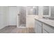 Bathroom with walk-in shower featuring gray tiles and granite countertop vanity at 12420 Brick Cobblestone Dr, Riverview, FL 33579