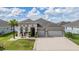 Lovely home with a three car garage, attractive landscaping, and a well-manicured lawn at 12420 Brick Cobblestone Dr, Riverview, FL 33579