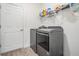 Laundry room with modern gray washer and dryer, shelving, and vinyl floor at 12420 Brick Cobblestone Dr, Riverview, FL 33579