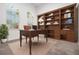 Home office with a built-in bookcase, a large window, and a wooden desk at 12420 Brick Cobblestone Dr, Riverview, FL 33579