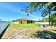 View of the backyard featuring a lush green lawn, vinyl fencing, and a cozy fire pit area at 13216 Antelope St, Spring Hill, FL 34609