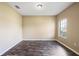 An empty bedroom showcases dark wood-look flooring and neutral walls with natural light from a window at 13216 Antelope St, Spring Hill, FL 34609