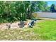 Image shows a cozy backyard fire pit with Adirondack chairs and a green lawn at 13216 Antelope St, Spring Hill, FL 34609