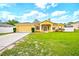 Charming single-story yellow home with a well-manicured front yard and a two-car garage with driveway at 13216 Antelope St, Spring Hill, FL 34609