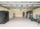 Spacious garage equipped with a refrigerator, water heater, and storage shelving at 13216 Antelope St, Spring Hill, FL 34609