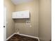 Laundry room featuring floating cabinets and dark vinyl wood-look flooring at 13216 Antelope St, Spring Hill, FL 34609
