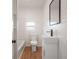 Bathroom featuring white vanity, modern fixtures, and a mirror, with white plank walls and laminate floor at 1527 E Lake Ave, Tampa, FL 33610