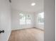 Bright bedroom with light wood floors and two large windows at 1527 E Lake Ave, Tampa, FL 33610