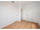 A simple bedroom features wood floors and access to another room via an open doorway at 1527 E Lake Ave, Tampa, FL 33610