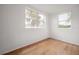 A bright bedroom featuring wood floors and two windows offering natural light at 1527 E Lake Ave, Tampa, FL 33610