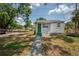 Exterior of charming single-story home with green door, stone walkway, and nicely maintained lawn at 1527 E Lake Ave, Tampa, FL 33610