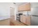 Well-lit kitchen featuring modern appliances, wooden cabinets and new wood floors at 1527 E Lake Ave, Tampa, FL 33610