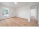 An airy living room with light-colored laminate flooring, freshly painted walls, and natural light at 1527 E Lake Ave, Tampa, FL 33610