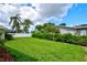 Spacious backyard with vibrant green grass and privacy hedging, ideal for relaxation and outdoor activities at 2132 Sandpiper Dr, Clearwater, FL 33764