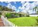 Expansive backyard featuring a screened-in porch and white fence, perfect for enjoying outdoor living at 2132 Sandpiper Dr, Clearwater, FL 33764