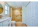 This updated bathroom has a tiled shower with a pebble floor, updated vanity, and updated flooring at 2132 Sandpiper Dr, Clearwater, FL 33764