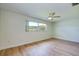 Bright bedroom with light wood floors, ceiling fan, and a window offering natural light at 2132 Sandpiper Dr, Clearwater, FL 33764