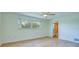 An empty bedroom with wood flooring has a window to the backyard and an ensuite bathroom at 2132 Sandpiper Dr, Clearwater, FL 33764
