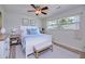 Bright bedroom featuring wood-look floors, a ceiling fan, and a large window with a view to the outside at 2132 Sandpiper Dr, Clearwater, FL 33764