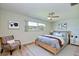 A stylish bedroom with a comfortable bed, cozy chair, and bright window overlooking neighborhood at 2132 Sandpiper Dr, Clearwater, FL 33764