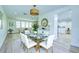 Dining room with stylish light fixture, glass table, and elegant decor at 2132 Sandpiper Dr, Clearwater, FL 33764