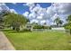 Beautifully landscaped front yard with lush green lawn and mature trees, creating a welcoming curb appeal at 2132 Sandpiper Dr, Clearwater, FL 33764