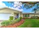 Charming home featuring a manicured lawn, mature landscaping, and a welcoming blue front door at 2132 Sandpiper Dr, Clearwater, FL 33764