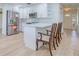 Bright kitchen features stainless steel appliances, white cabinets, and island with chairs at 2132 Sandpiper Dr, Clearwater, FL 33764
