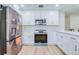 Bright kitchen features stainless steel appliances, white cabinets, and hardwood floors at 2132 Sandpiper Dr, Clearwater, FL 33764